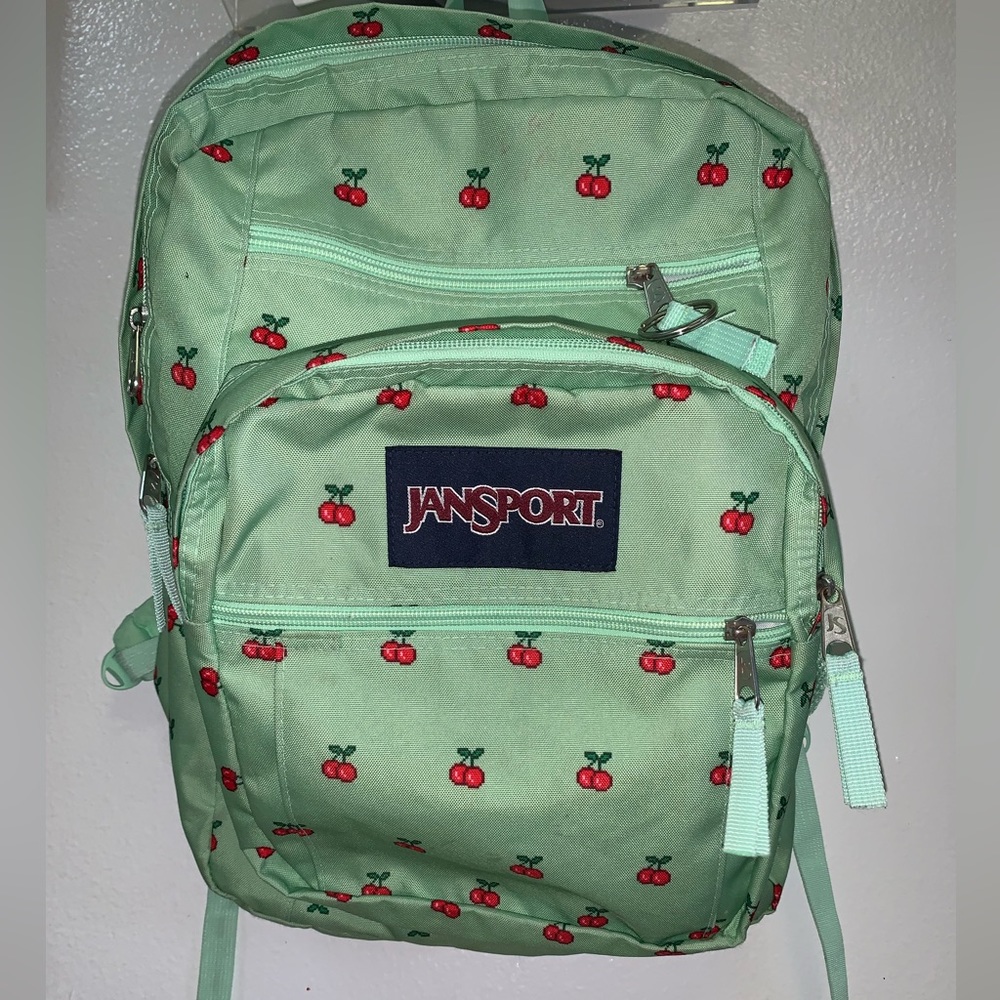 Large 3 compartment Jansport green backpack with cherries.